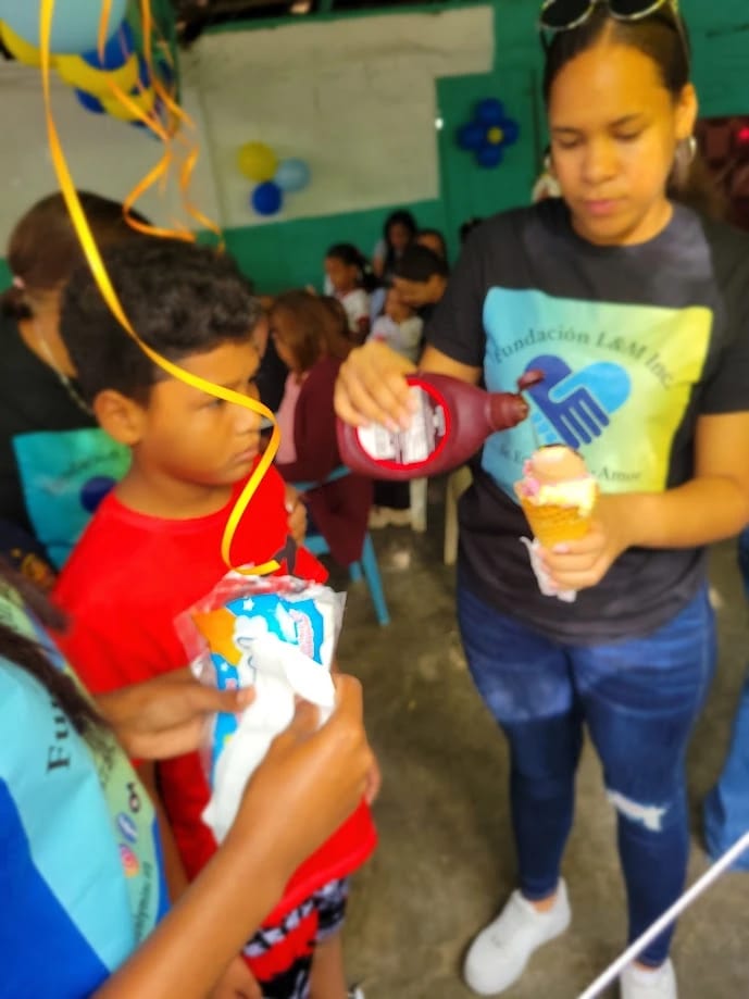 Voluntaria sirviendo helado a un niño